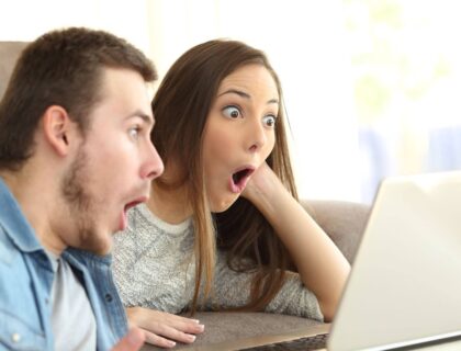 An excited couple learning how to find someone's email on a Laptop.